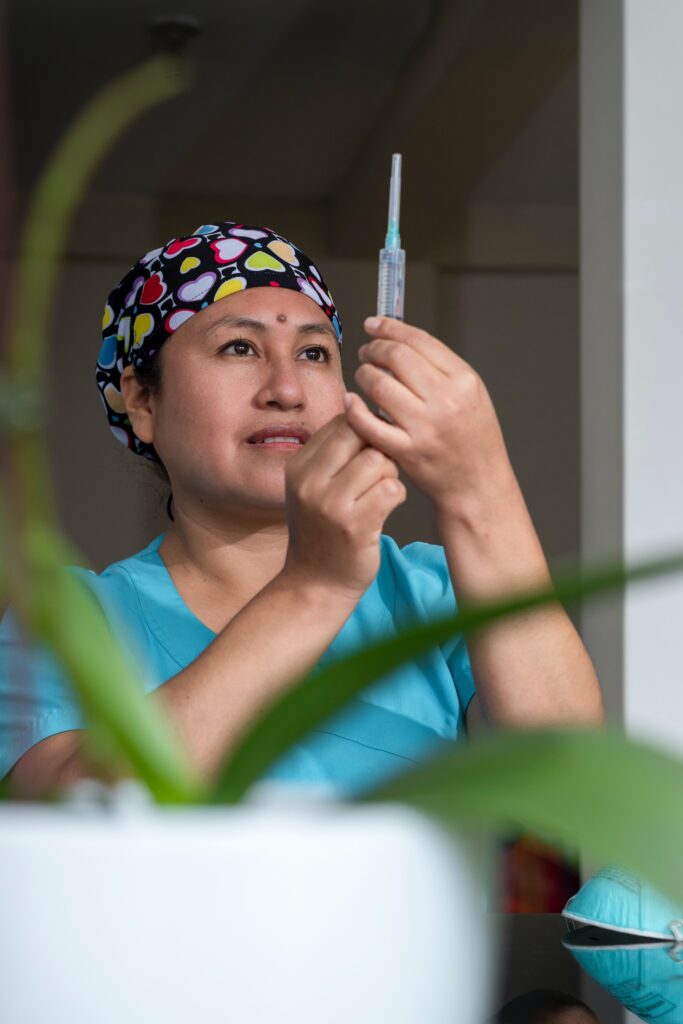 A woman with a nursing degree, preparing a syringe or medication